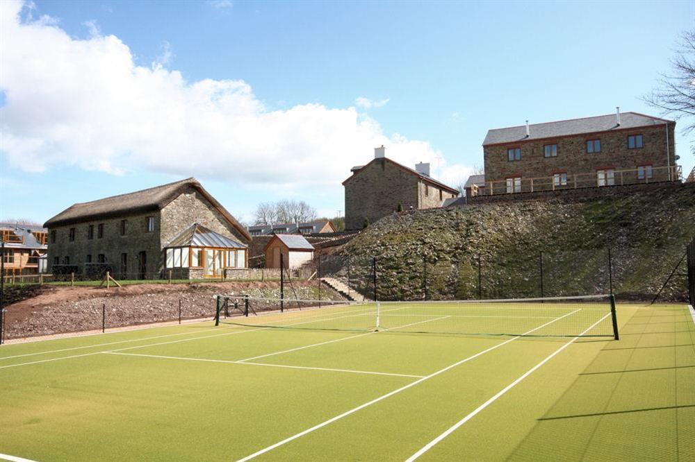 The tennis court is just a few yards from the cottage at Courtyard Cottage in , Dartmouth