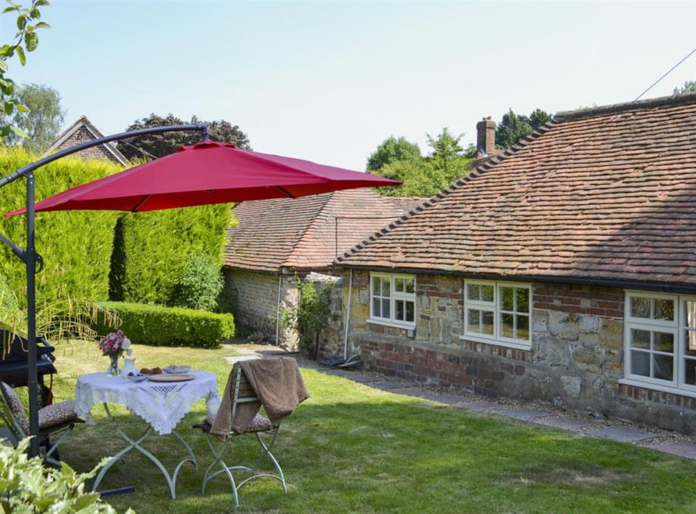 Enclosed garden with garden furniture and barbecue at Cowbeech Farm Cottage in Cowbeech, near Hailsham, East Sussex