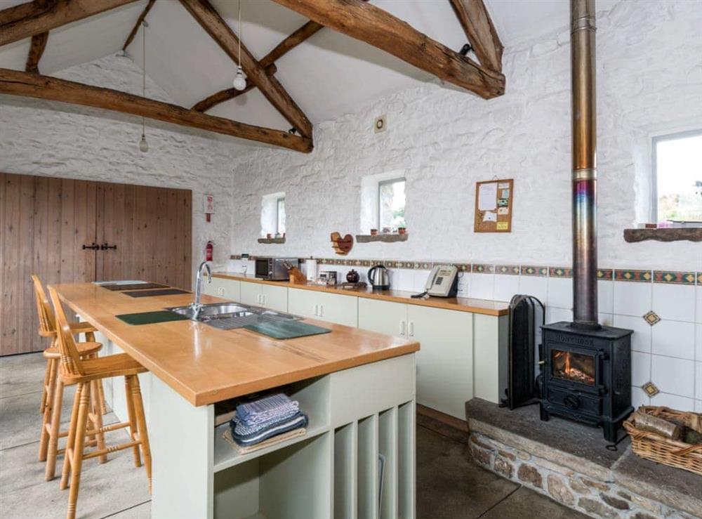 Kitchen/diner with exposed beams and a wood burning fire at Cowdber Barn in Burrow, Kirkby Lonsdale, Cumbria., Lancashire