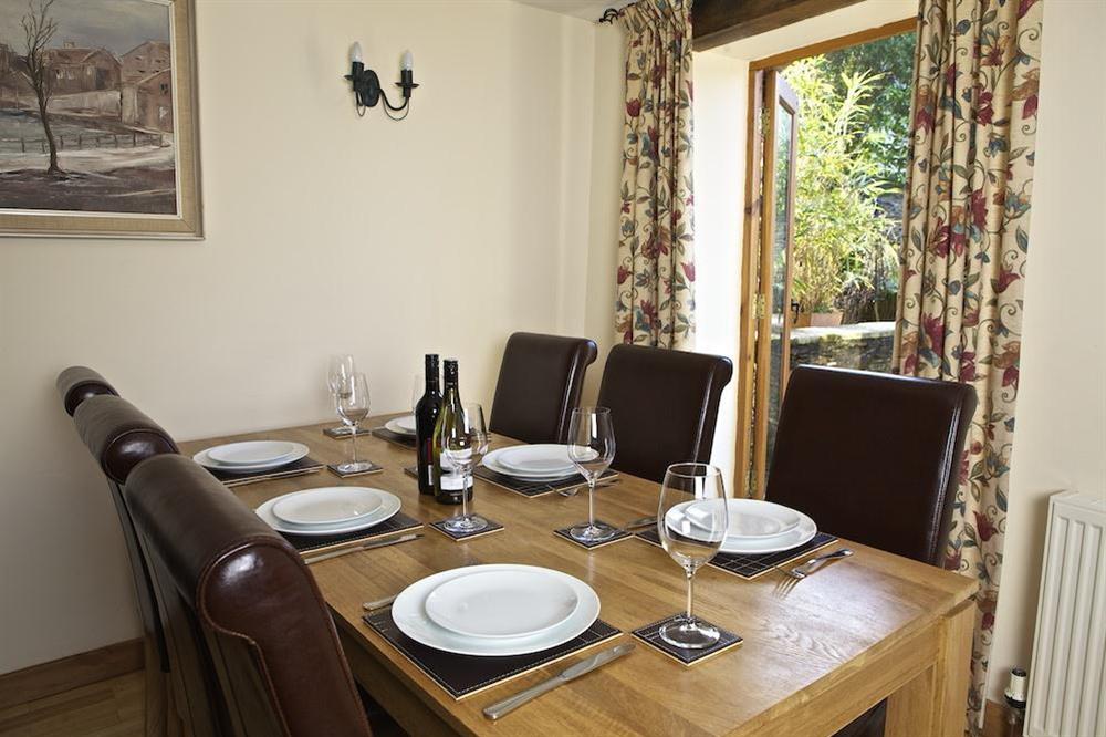 Dining area with table, six chairs and doors to rear terrace at Cowslip Cottage in Frogmore, Nr Kingsbridge