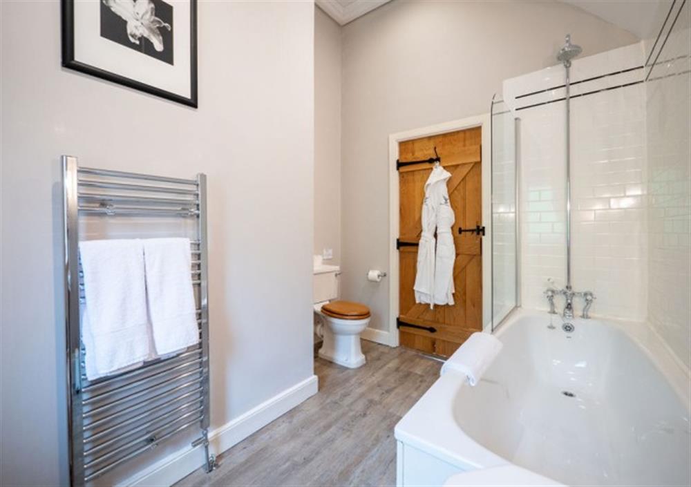 Bedroom 1 ensuite with bath and overhead shower at Cox Tor in Chagford