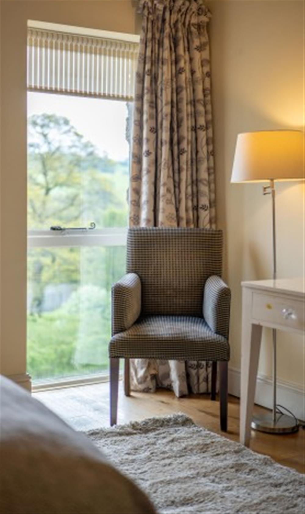Bedroom 1 with armchair and views over surrounding scenery at Cox Tor in Chagford