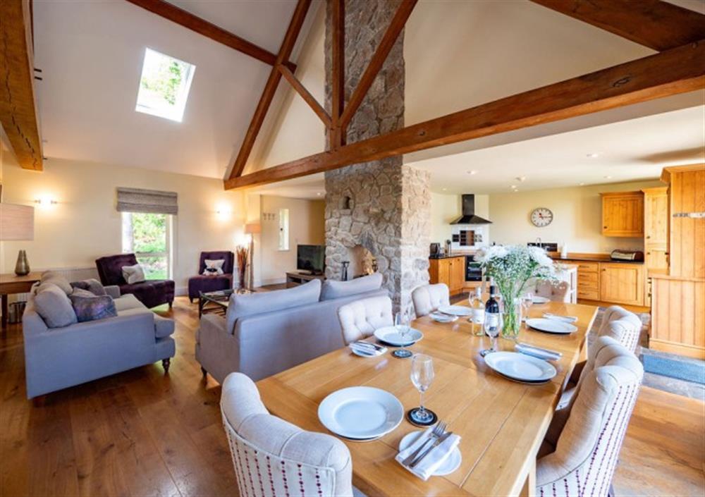 Open-plan dining area and sitting room with feature stone fireplace at Cox Tor in Chagford