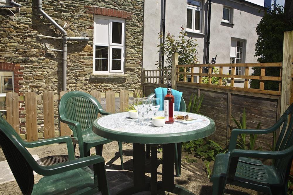 To the rear of the property is a small and enclosed, private terrace with garden furniture at Coxswains Watch in 59 Fore Street, Salcombe