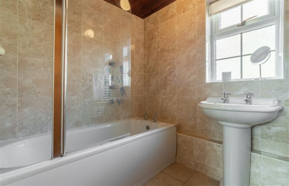 First floor: Family bathroom with bath, overhead shower, wash basin and heated towel rail  at Crabpot Cottage, East Runton near Cromer