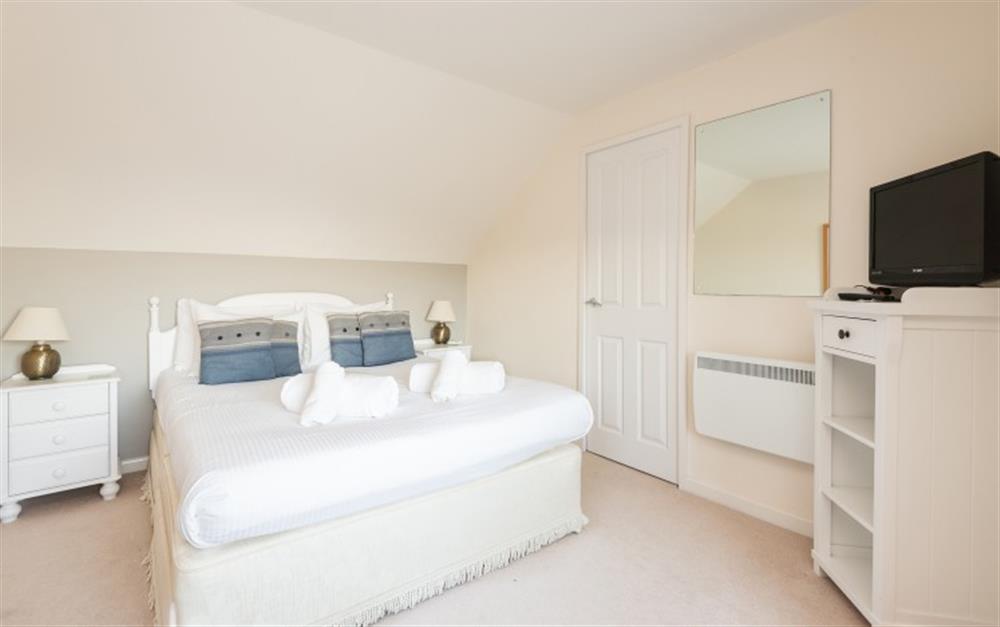 The master bedroom is located on the first floor and has a walk in wardrobe, to the right of the bed. at Crags 26 Bay View Cottage in Maenporth