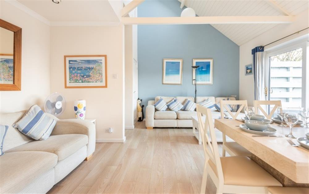 The view of the lounge from the kitchen showing the feature wall and coastal artwork at Crags 26 Bay View Cottage in Maenporth