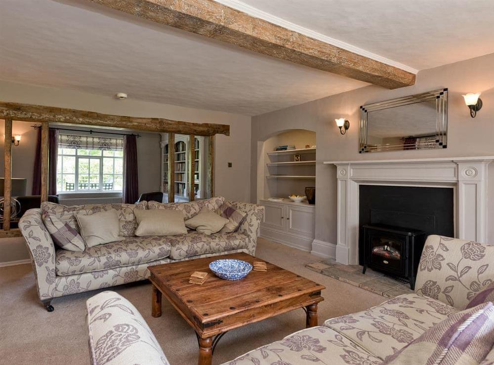 Spacious sitting room equipped with electric woodburner at Cravens Manor in Henham, near Southwold, Suffolk