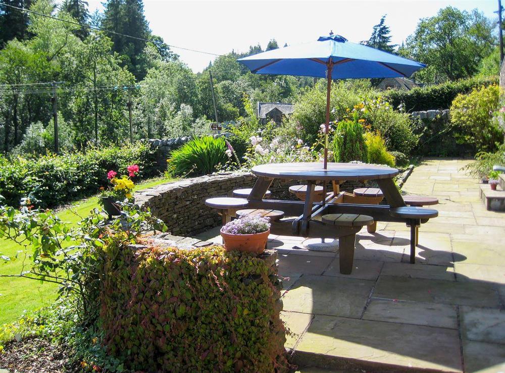 Lawned garden with sitting-out area and garden furniture at Creag Darach Cottage in Aberfoyle, near Callander, Stirlingshire, Scotland