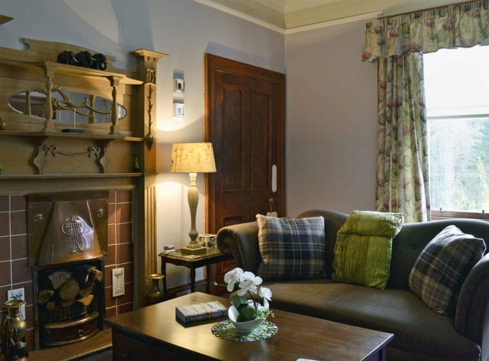 Tastefully furnished living room with open fire at Creag Darach Cottage in Aberfoyle, near Callander, Stirlingshire, Scotland