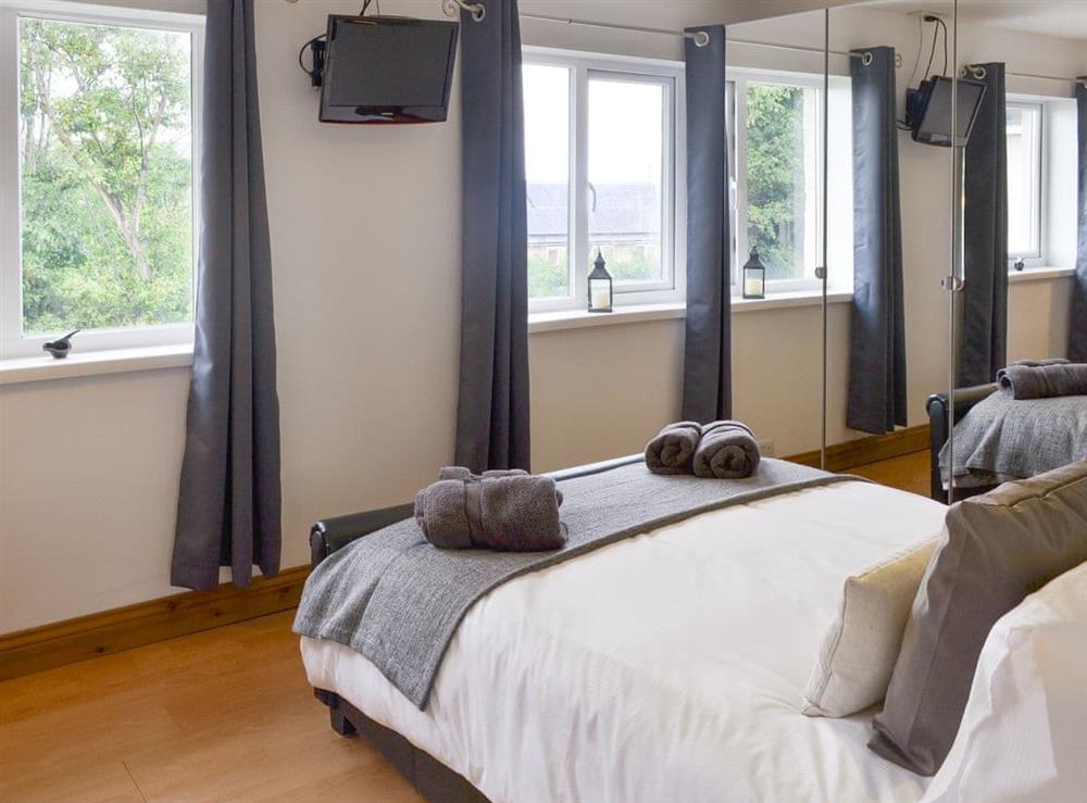 Comfortable double bedroom with built-in mirrored storage at Crew House in Craster, near Alnwick, Northumberland