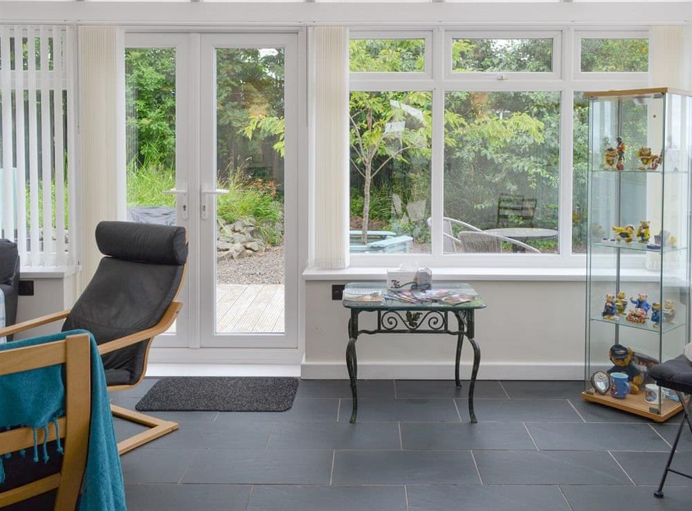 Spacious conservatory with French doors to patio area at Crew House in Craster, near Alnwick, Northumberland
