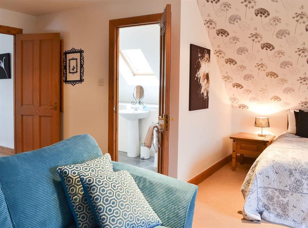Double bedroom with seating area and en-suite at Croftside House in Aviemore, Inverness-Shire