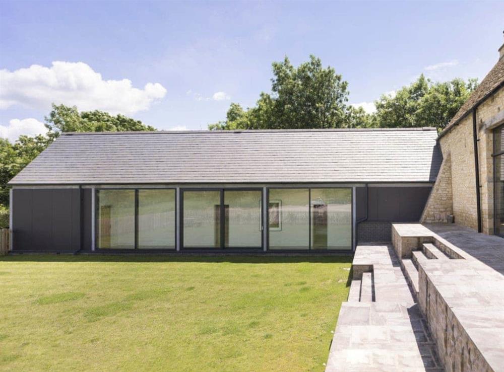 Lawned garden and contemporary extension at The Cotswolds Barn, 