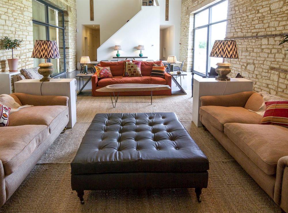 Spacious living area with exposed stone feature walls at The Cotswolds Barn, 
