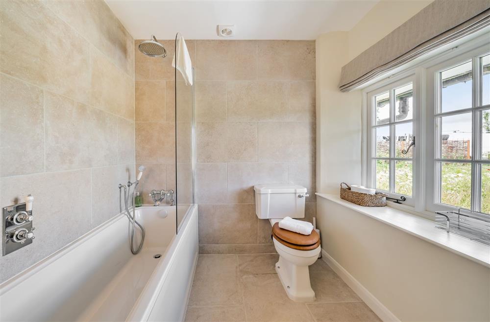The bath with overhead shower at Crumpet Cottage, Dorchester