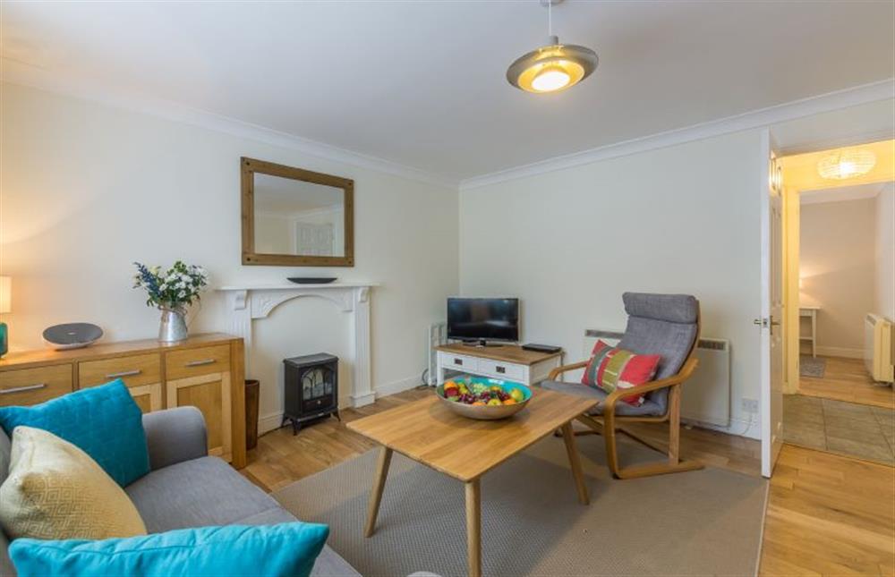Ground floor: Comfortable sitting room with electric wood burner effect fire at Curlew Apartment, Wells-next-the-Sea
