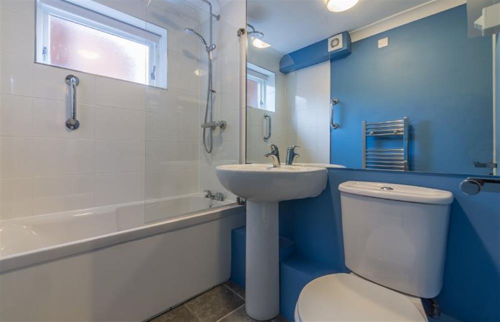 Ground floor: The bathroom has bath with shower over and handy grab rail at Curlew Apartment, Wells-next-the-Sea
