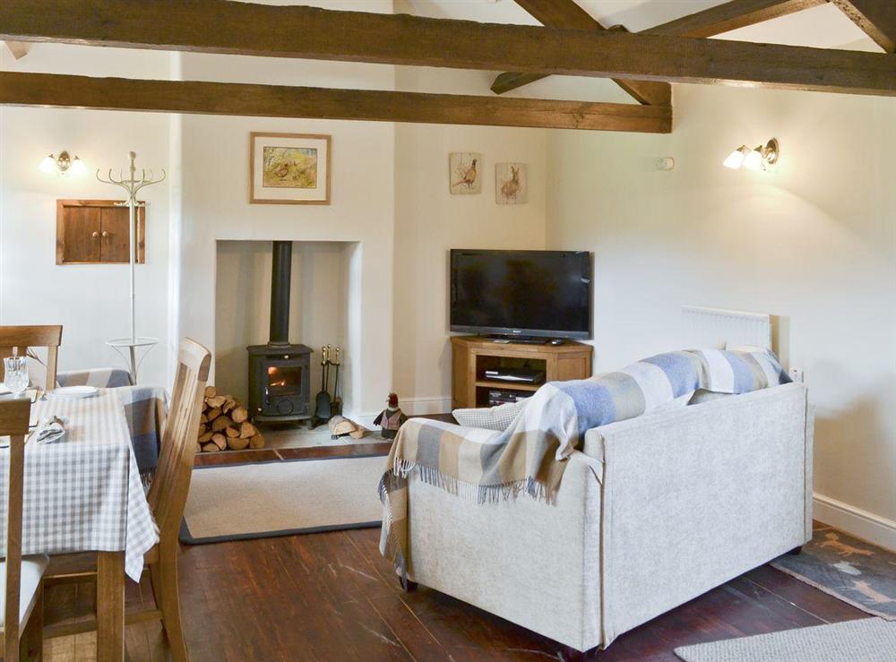 Cosy living area with wood-beamed ceiling at Curlew Barn in Leyburn, North Yorkshire