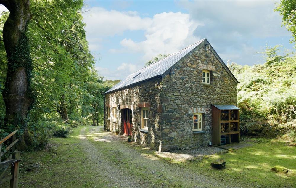 The cottage is set in a wooded hillside at Cwm Bach, Dinas Cross