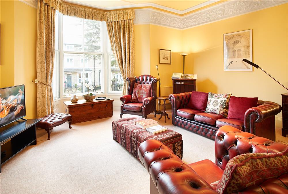 Sitting room with leather seating, decorative fire place and bay window