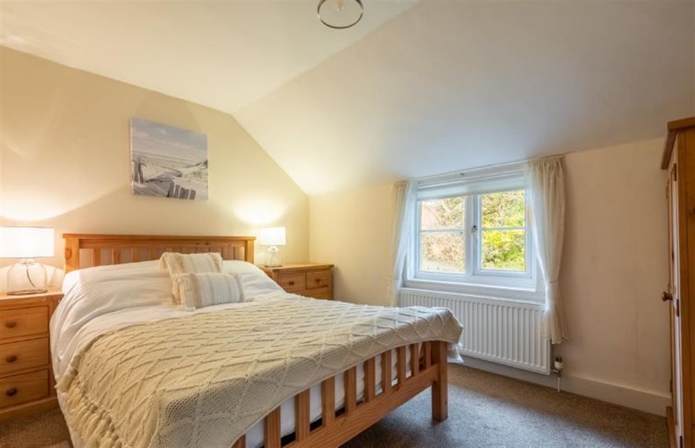 First floor: Master bedroom with a double bed at Daisy Cottage, Holt