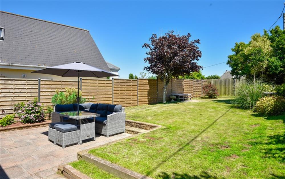 Terrace and garden with rattan seating at Daisy Cottage in Malborough