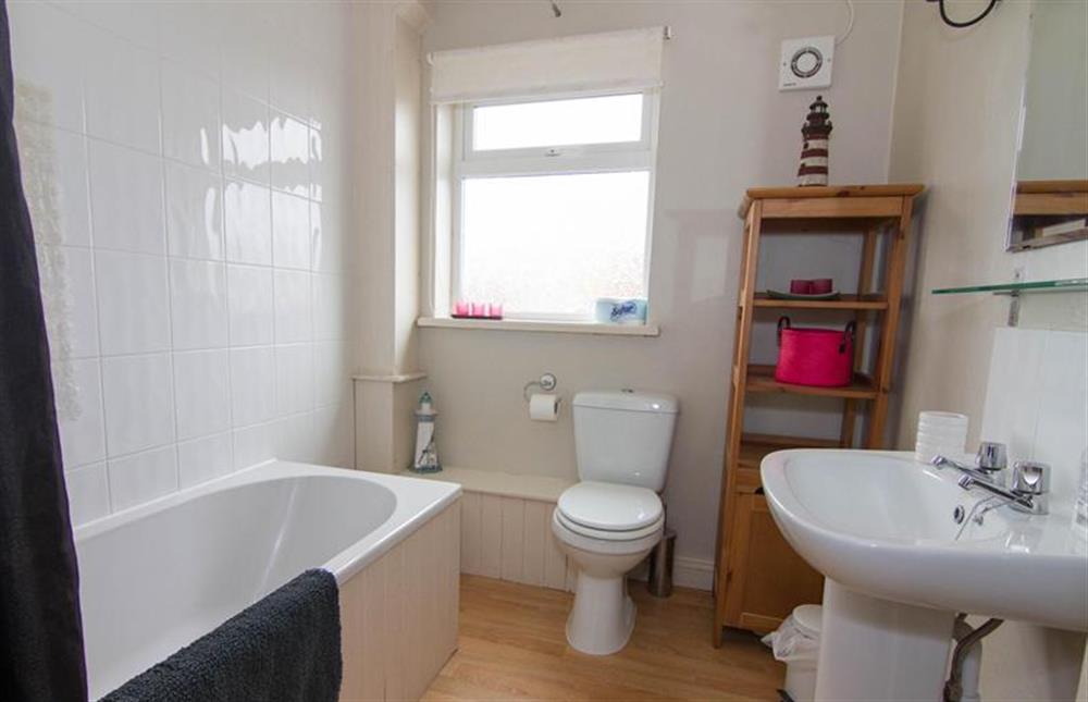 First floor:  Bathroom with bath with power shower over at Daisy Cottage, Northrepp near Cromer