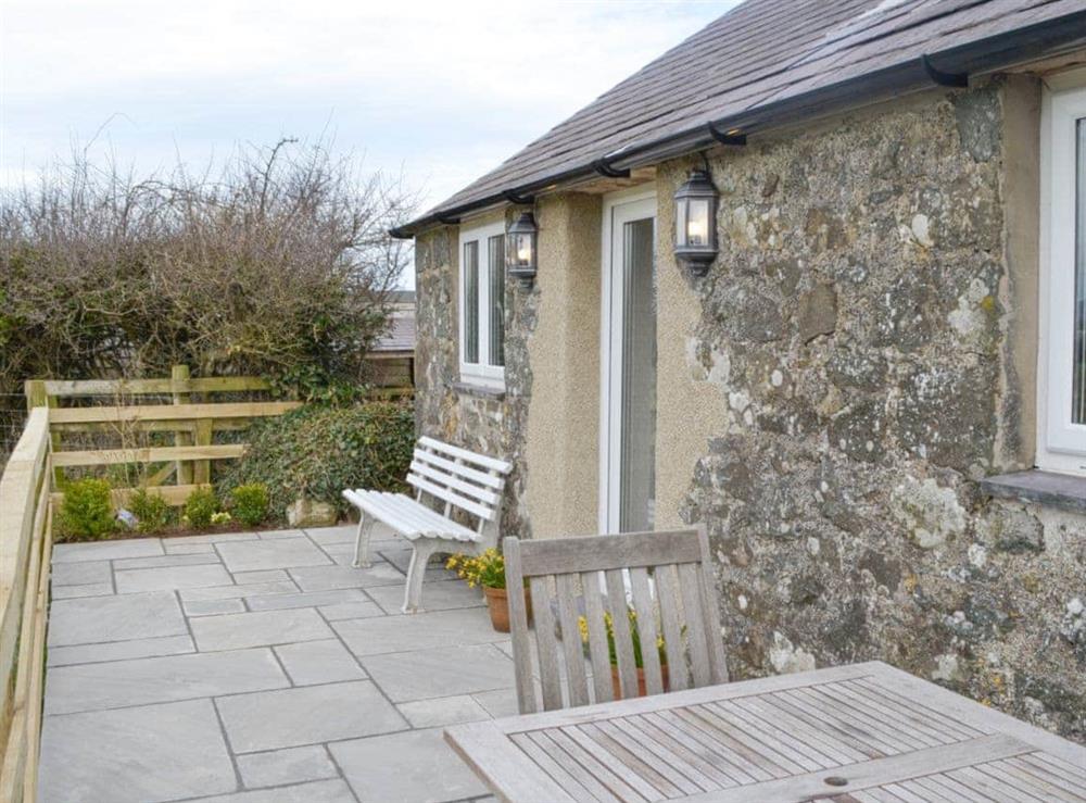 Paved patio area with outdoor furniture at Daisy Cottage in Pwllheli, Gwynedd
