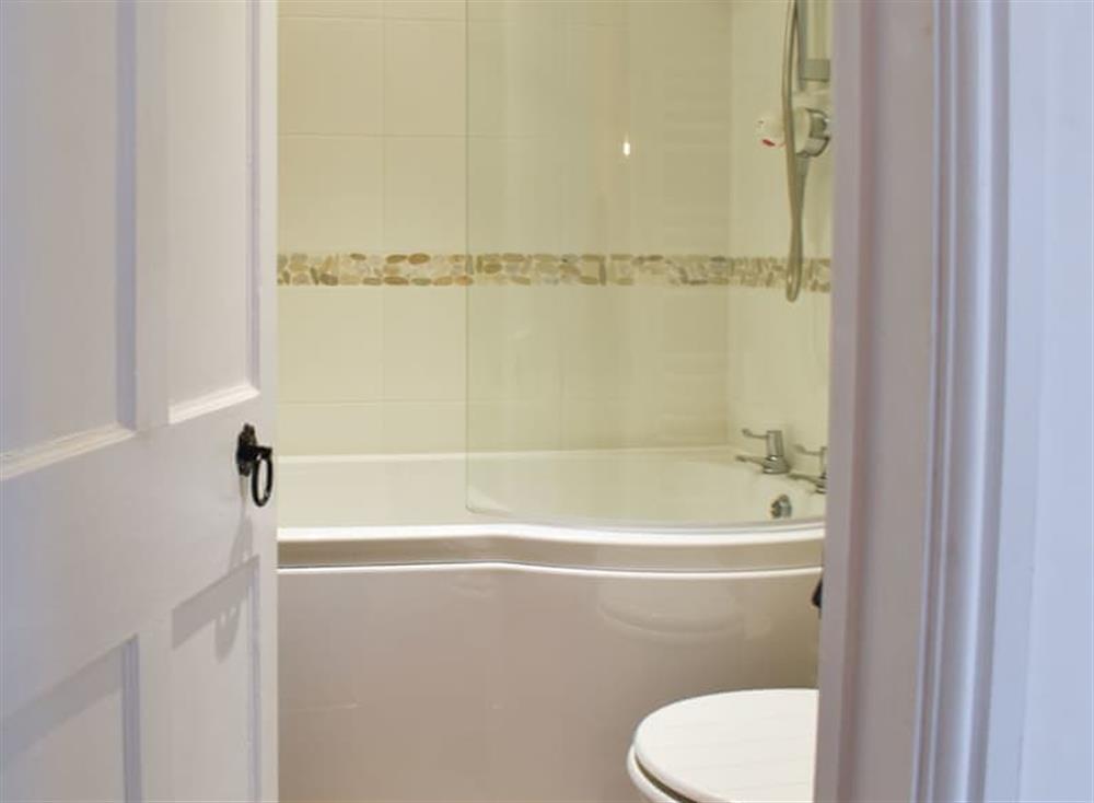 Bathroom with shower over the bath at Daisy Cottage in Shaldon, Devon