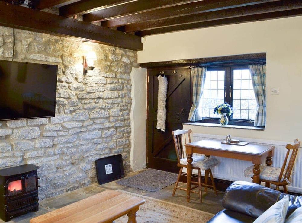 Cosy living area with exposed stone wall at Dale House Farm Cottage in Monyash, near Bakewell, Derbyshire