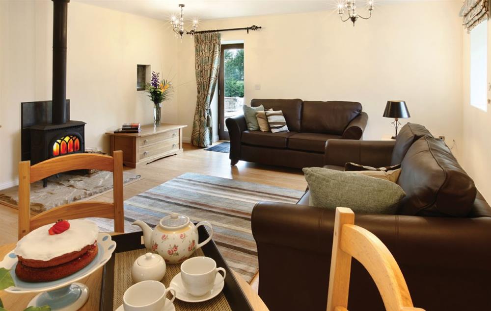 Large living room with single patio door and access to private patio and garden area at Damson Cottage, Rainow