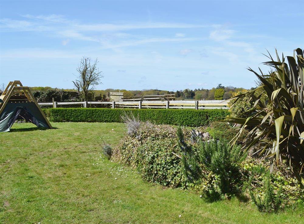Lareg garden with furniture, barbeque and childrens’ play area at Daneshurst Cottage in Tiptoe, near Lymington, Hampshire