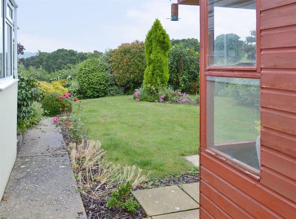 Lawned area front and rear. Rear garden is pet secure with summerhouse containing garden furniture -  sufficient room to store cycles. at Dart Corner in Bovey Tracey, Devon