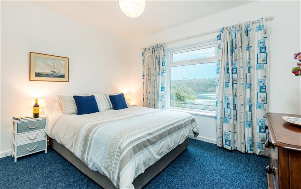 You'll love the master bedroom with its beachy feel and stunning views of the river. at Demelza 1 in Helford Passage