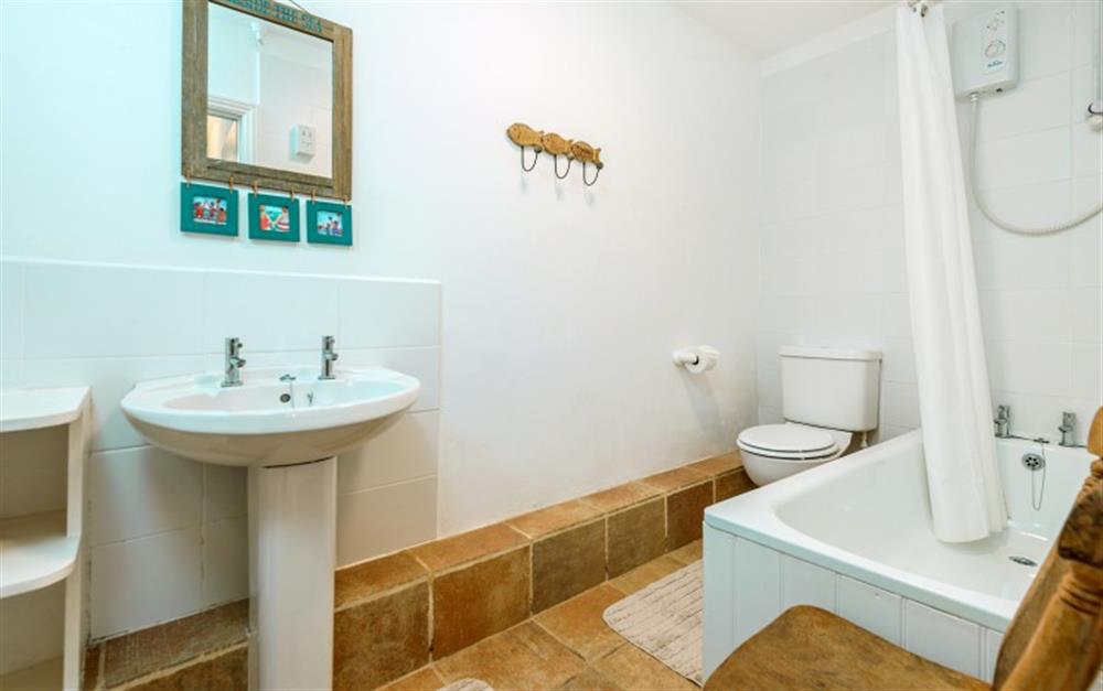 The family bathroom has both a bath and overhead electric shower to suit everyone's taste. at Demelza 2 in Helford Passage