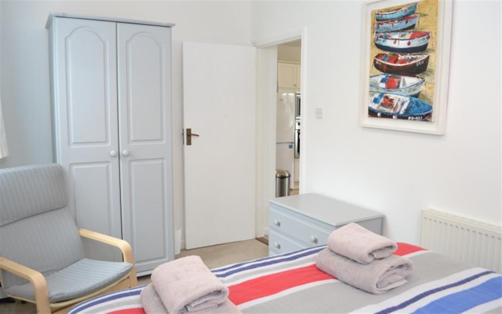 The light grey bedroom furniture looks great against the vibrant red and blue bedding. at Demelza 2 in Helford Passage