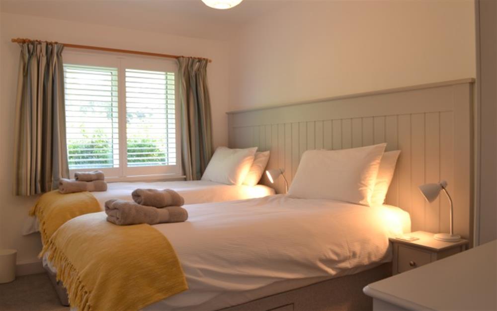 The yellow throws add a splash of colour to the neutral tones in the twin bedroom. at Demelza 3 in Helford Passage