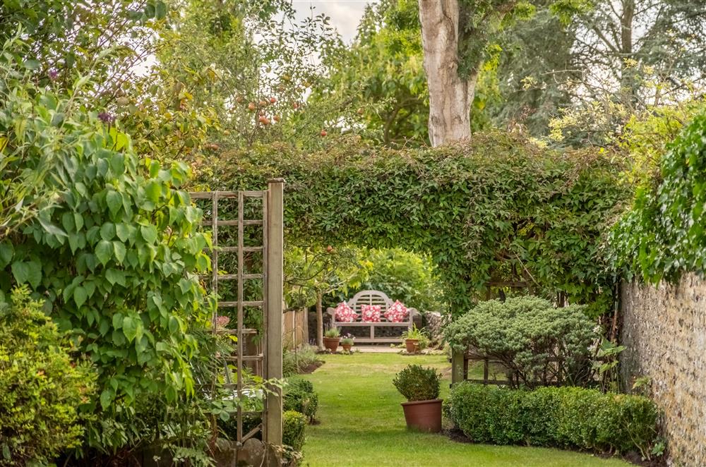 The pretty garden leading to a contemplative bench seating area at Densford Cottage, Amberley