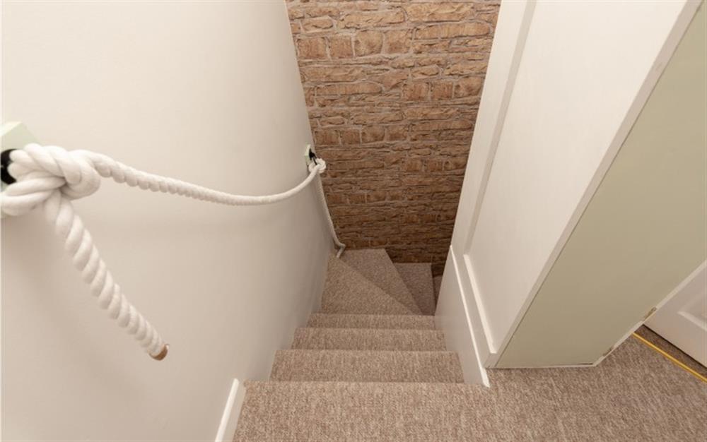 The steep cottage-style stairs lead from the first floor back down to the lounge area. at Diesel's Den in Bideford