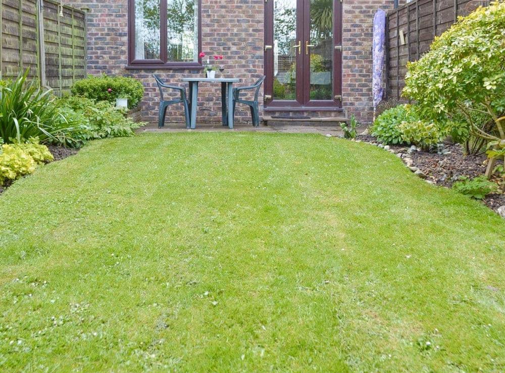 Lawned rear garden at Dinsdale in Rustington, near Worthing, West Sussex