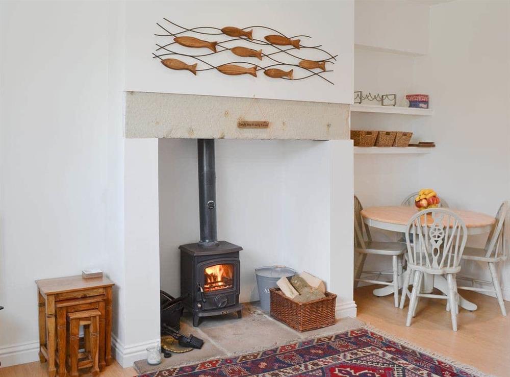 Cosy living area with wood burner at Dipper Cottage in Seahouses, Northumberland
