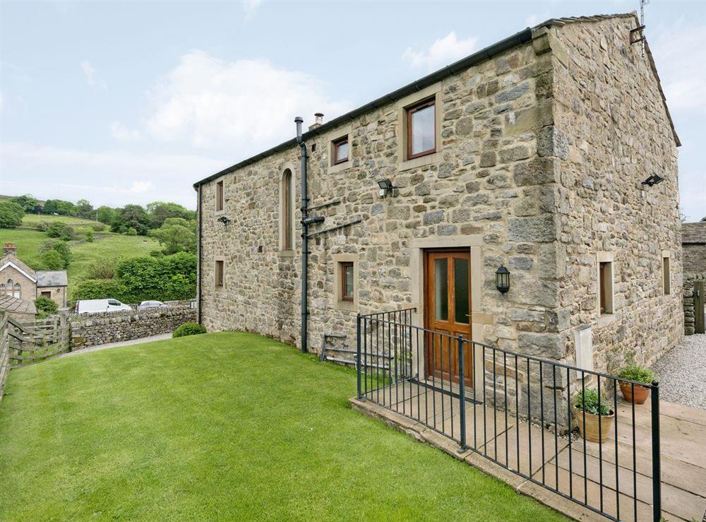 Enclosed lawned garden with patio and furniture at Dipper Fold in Hebden, near Skipton, North Yorkshire