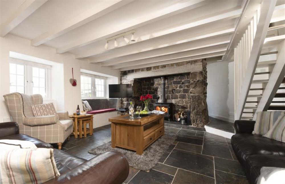 The sitting room with sumptuous seating and a wood burning stove at Dolor Cottage, Coverack