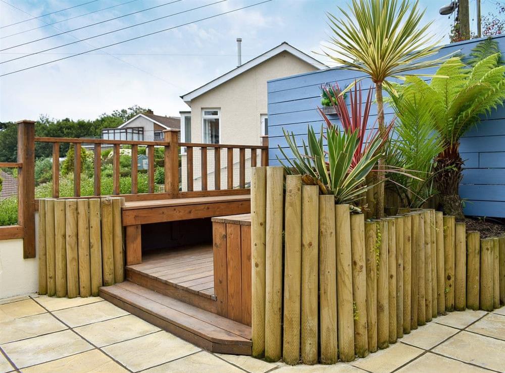 Enclosed courtyard with garden furniture and summerhouse at Dolphin Watch in Newlyn, Cornwall