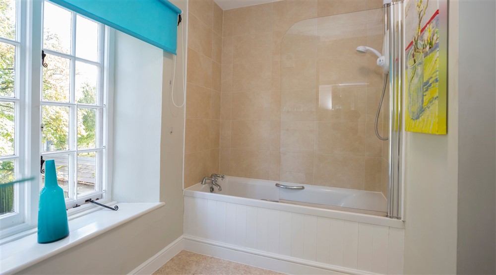 The bathroom with shower over bath at Downhouse Farm Cottage in Bridport, Dorset