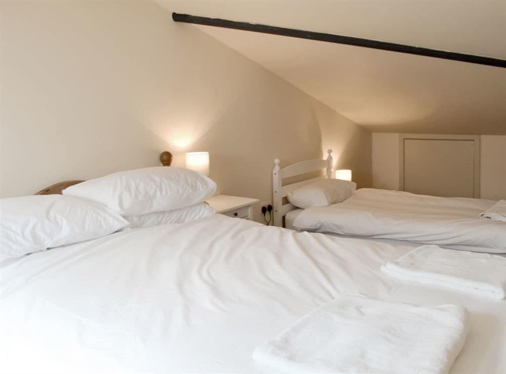 Family bedroom with single and double beds at Louisas Cottage, 