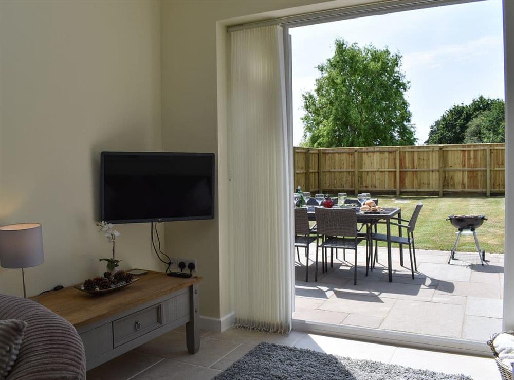 Lounge area with patio doors leading to garden at Downton Cottage in Downton, near Lymington, Hampshire