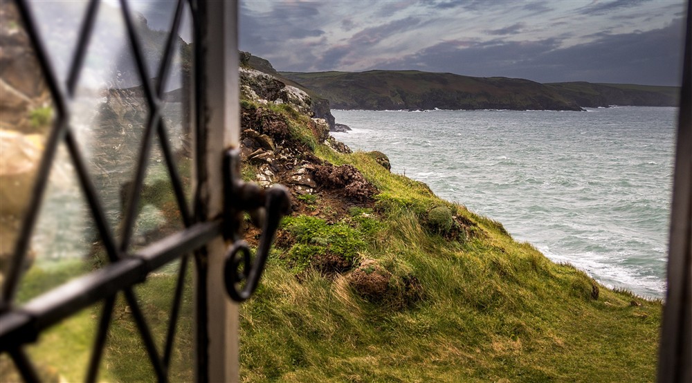 A coastal view from a window at Doyden Castle in Port Quin, Cornwall