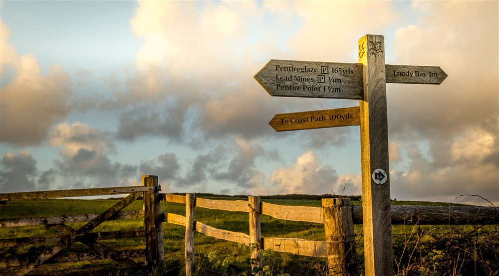 A sign with local footpaths near Doyden Castle, Cornwall at Doyden Castle in Port Quin, Cornwall